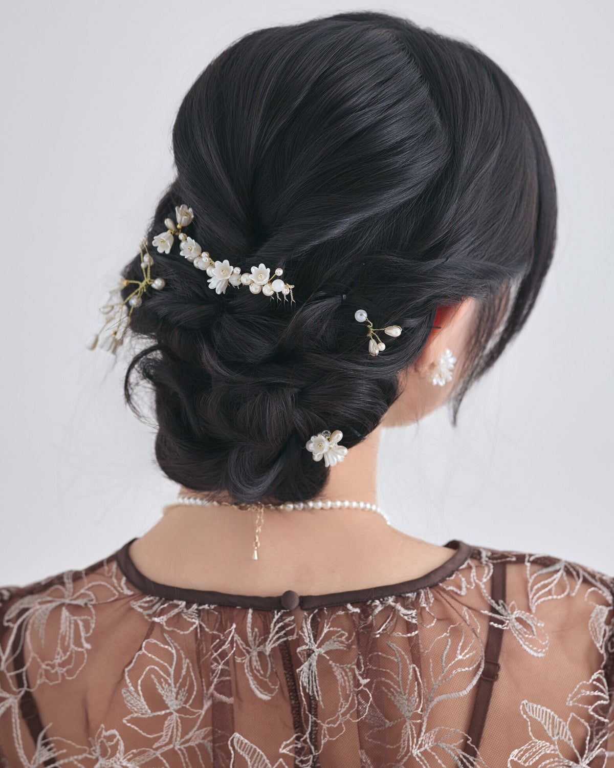 モデルがパールヘアピンを複数使いしてアレンジしたヘアスタイルの背面 パターン１ ゴールド