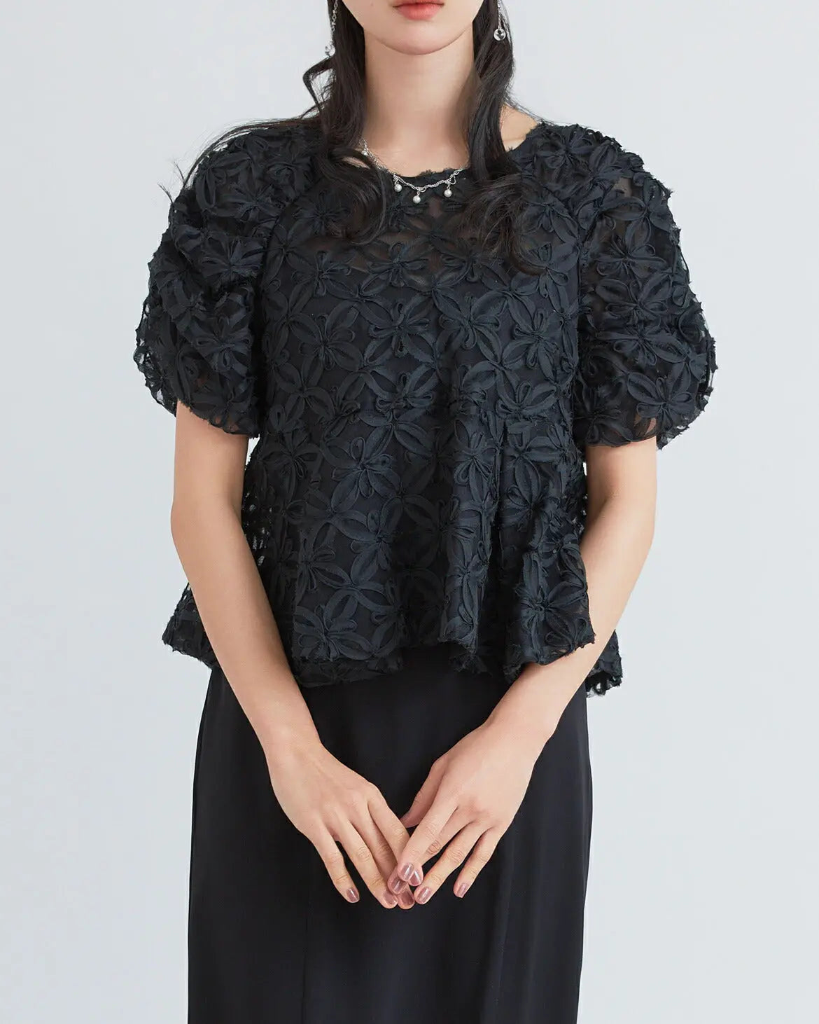 モデル着用:立体的な刺繍生地を使用したトップスとペプラムデザインのウエスト切り替え 正面 ブラック
