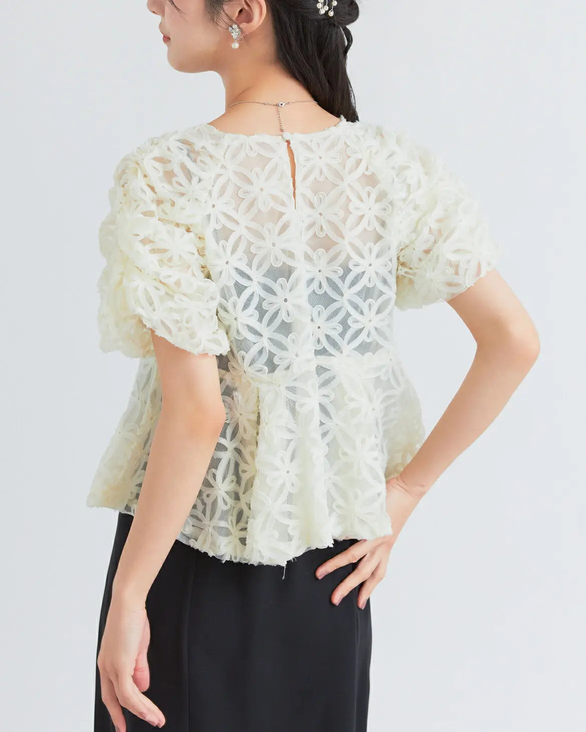 モデル着用:立体的な刺繍生地を使用したトップスとペプラムデザインのウエスト切り替え 上半身アップ バックスタイル ベージュxブラック
