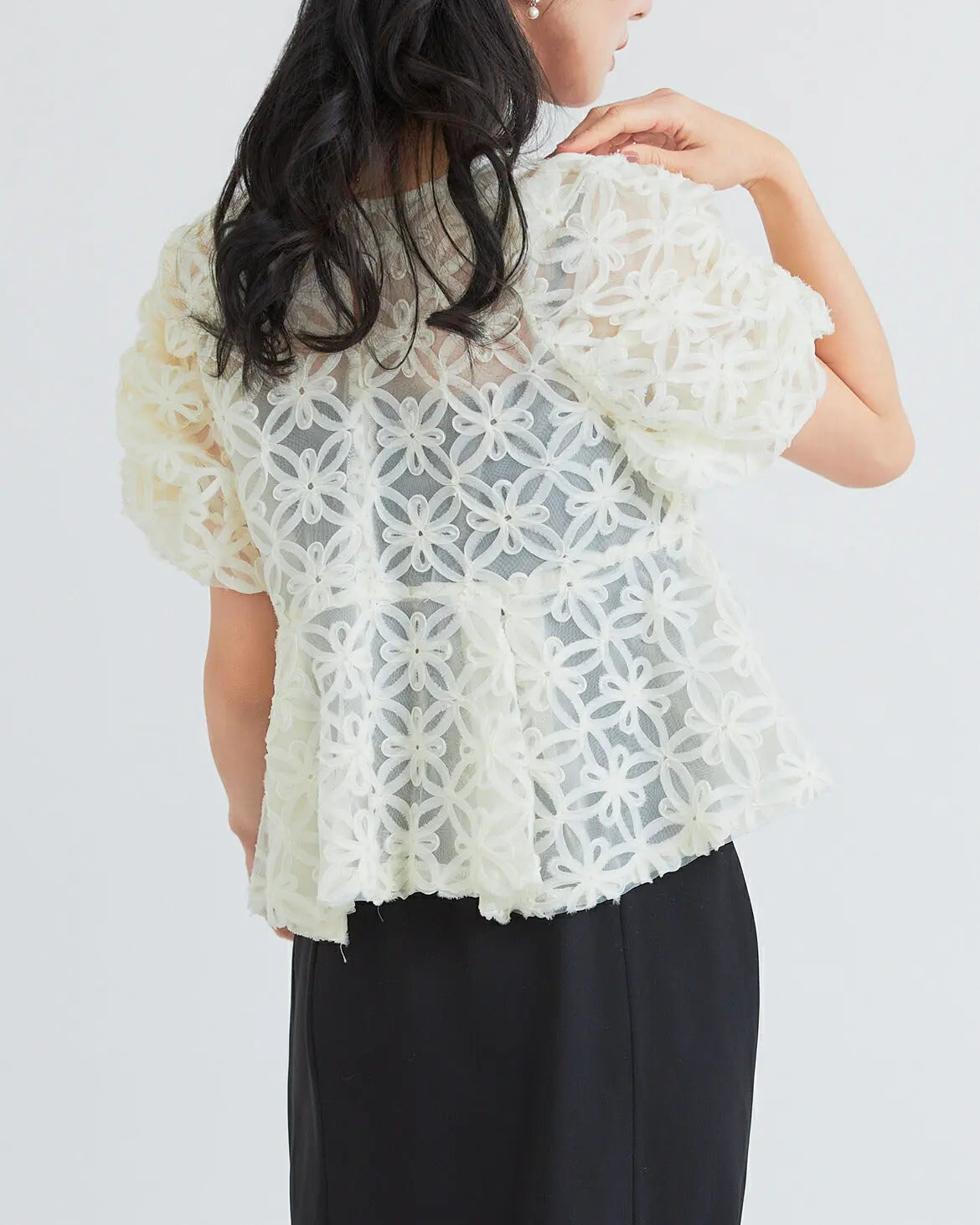 モデル着用:立体的な刺繍生地を使用したトップスとペプラムデザインのウエスト切り替え 上半身アップ バックデザイン２ ベージュxブラック